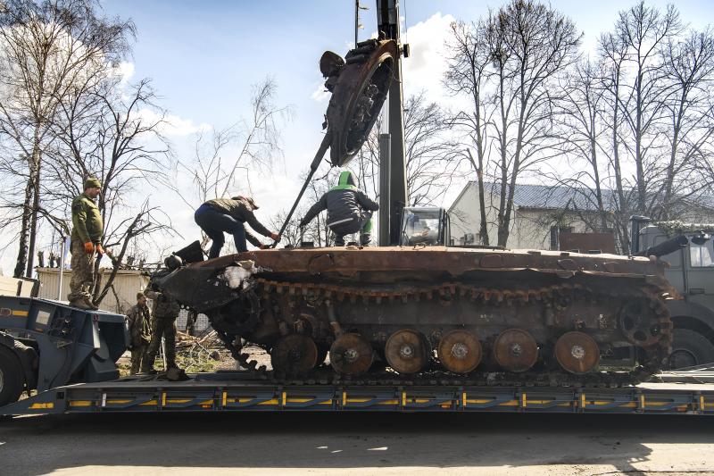Workers remove a destroyed Russian military tank from the road near Andriivka, a village close to Kyiv, Ukraine, on Monday. Workers remove a destroyed Russian military tank from the road near Andriivka, a village close to Kyiv, Ukraine, on Monday.