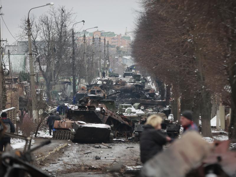 People look at the gutted remains of Russian military vehicles on a road in the town of Bucha, close to Ukraine's capital, Kyiv, on Tuesday. People look at the gutted remains of Russian military vehicles on a road in the town of Bucha, close to Ukraine's capital, Kyiv, on Tuesday.
