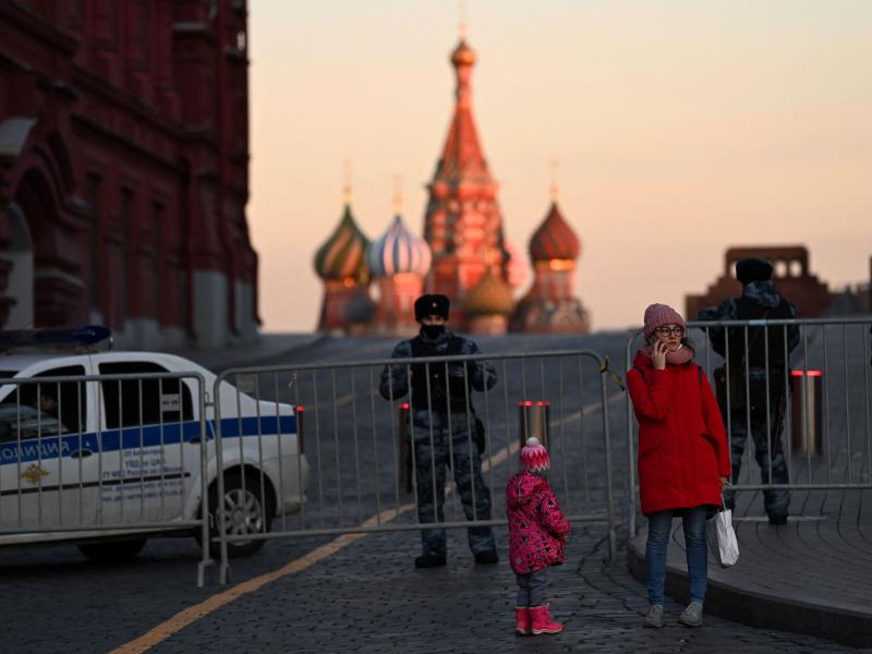 A woman makes a phone call in front of police officers blocking access to Red Square in central Moscow on March 2, 2022 A woman makes a phone call in front of police officers blocking access to Red Square in central Moscow on March 2, 2022