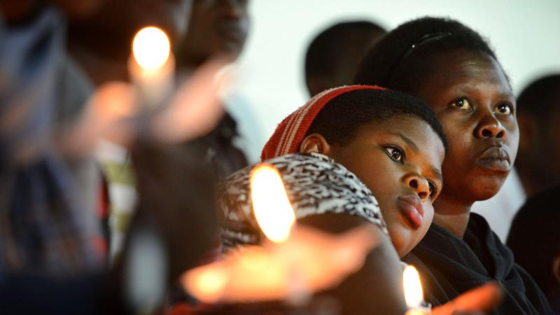 Rwandan women hold candles during a night vigil and prayer for genocide victims at Amahoro stadium. Rwandan women hold candles during a night vigil and prayer for genocide victims at Amahoro stadium.