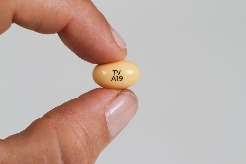A progesterone pill held between a woman's fingers. A progesterone pill held between a woman's fingers.