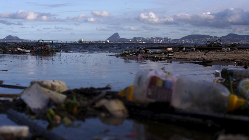 Concerns about pollution in the waters around Rio have prompted the world sailing federation to take action ahead of next year's Olympic Games. Here, garbage is seen on Bica Beach, on the banks of the Guanabara Bay, with the Sugar Loaf mountain in backgro Concerns about pollution in the waters around Rio have prompted the world sailing federation to take action ahead of next year's Olympic Games. Here, garbage is seen on Bica Beach, on the banks of the Guanabara Bay, with the Sugar Loaf mountain in backgro
