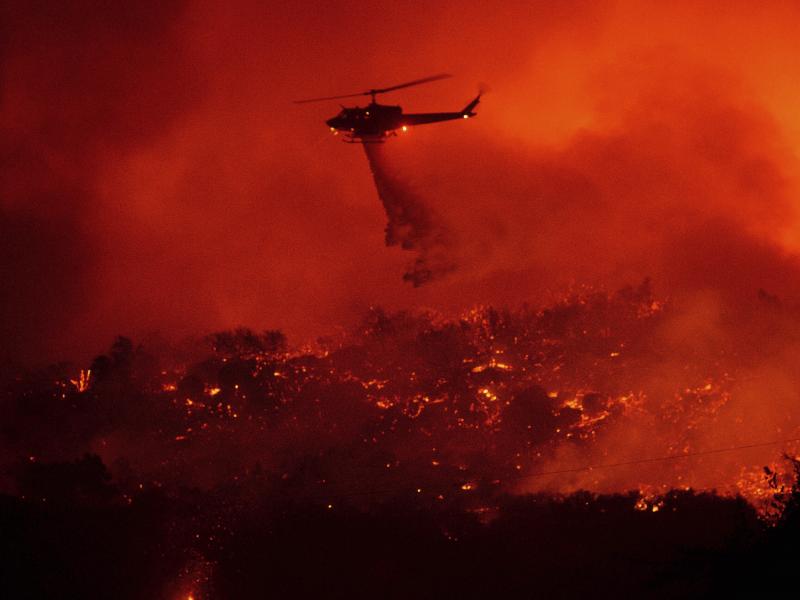 A helicopter drops water on the Cave Fire burning in the Los Padres National Forest above Santa Barbara, Calif., on Tuesday. A helicopter drops water on the Cave Fire burning in the Los Padres National Forest above Santa Barbara, Calif., on Tuesday.