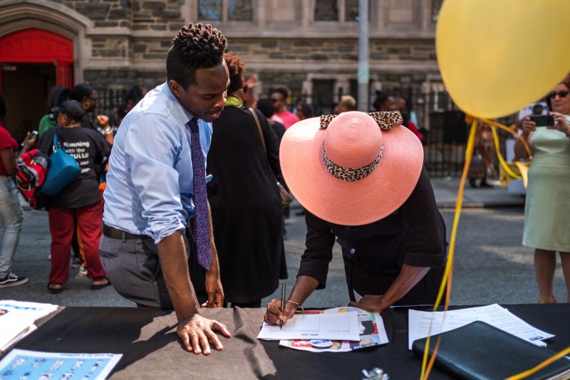 Kolbi Brown (left), a program manager at Harlem Hospital in New York, helps Karen Phillips sign up to receive more information about the All of Us medical research program, during a block party outside the Abyssinian Baptist Church in Harlem. Kolbi Brown (left), a program manager at Harlem Hospital in New York, helps Karen Phillips sign up to receive more information about the All of Us medical research program, during a block party outside the Abyssinian Baptist Church in Harlem.