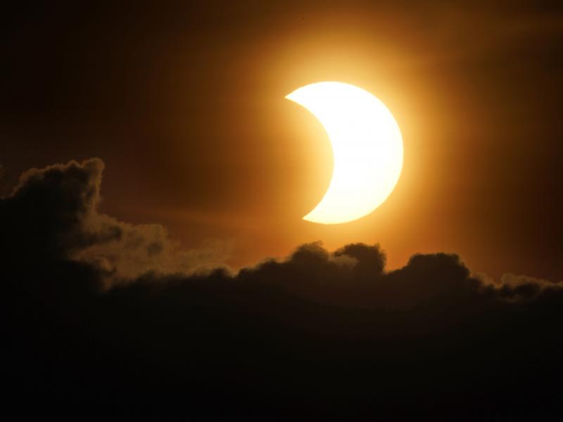 The sun is partially eclipsed as it rises over lower Manhattan in New York on Thursday. The sun is partially eclipsed as it rises over lower Manhattan in New York on Thursday.