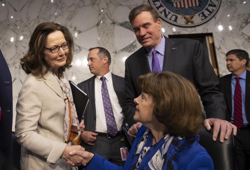 Gina Haspel (in white), the nominee to lead the CIA, is welcomed at her confirmation hearing before the Senate intelligence committee by Sen. Dianne Feinstein, D-Calif. (seated), and Vice Chairman Mark Warner, D-Va., in Washington on May 9. The committee Gina Haspel (in white), the nominee to lead the CIA, is welcomed at her confirmation hearing before the Senate intelligence committee by Sen. Dianne Feinstein, D-Calif. (seated), and Vice Chairman Mark Warner, D-Va., in Washington on May 9. The committee