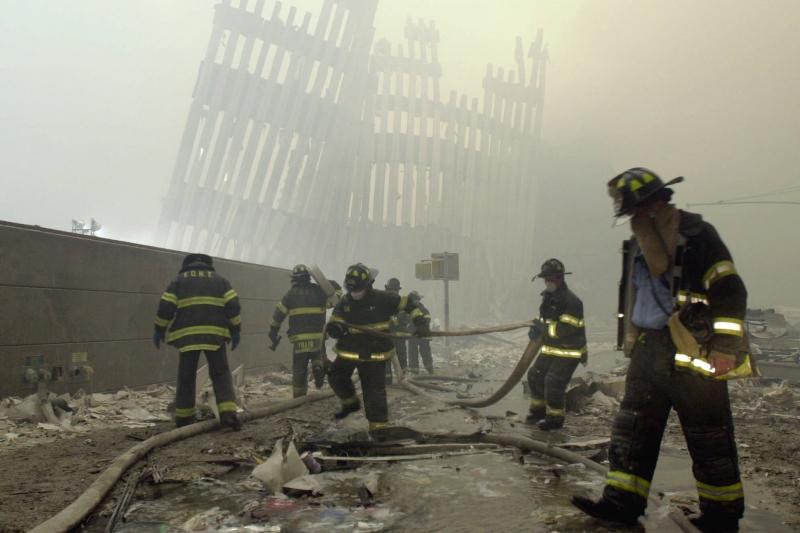 Firefighters work beneath the vertical struts of the World Trade Center's twin towers, in Lower Manhattan, following the attacks of Sept. 11, 2001. Firefighters work beneath the vertical struts of the World Trade Center's twin towers, in Lower Manhattan, following the attacks of Sept. 11, 2001.