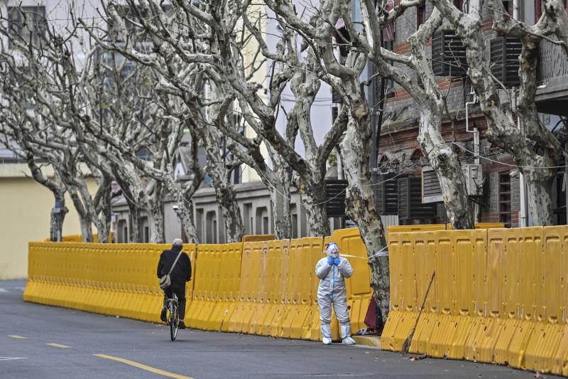 A worker in protective gear stands by barriers set up as part of lockdown measures against COVID-19 in Jing'an district, in Shanghai on March 31. A worker in protective gear stands by barriers set up as part of lockdown measures against COVID-19 in Jing'an district, in Shanghai on March 31.