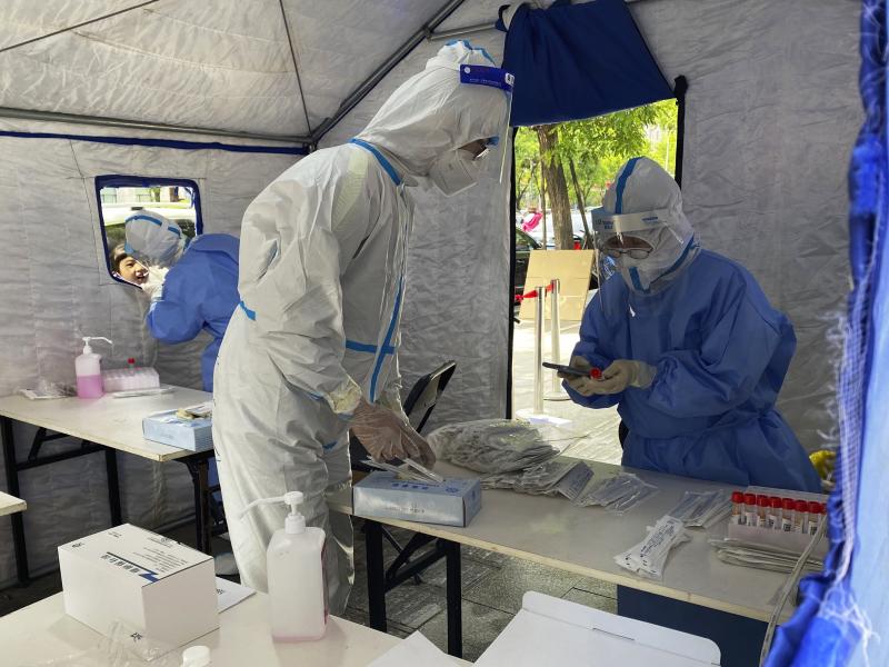 Workers in protective overalls conduct mass COVID testing for residents on May 11, 2022, in Beijing. Workers in protective overalls conduct mass COVID testing for residents on May 11, 2022, in Beijing.