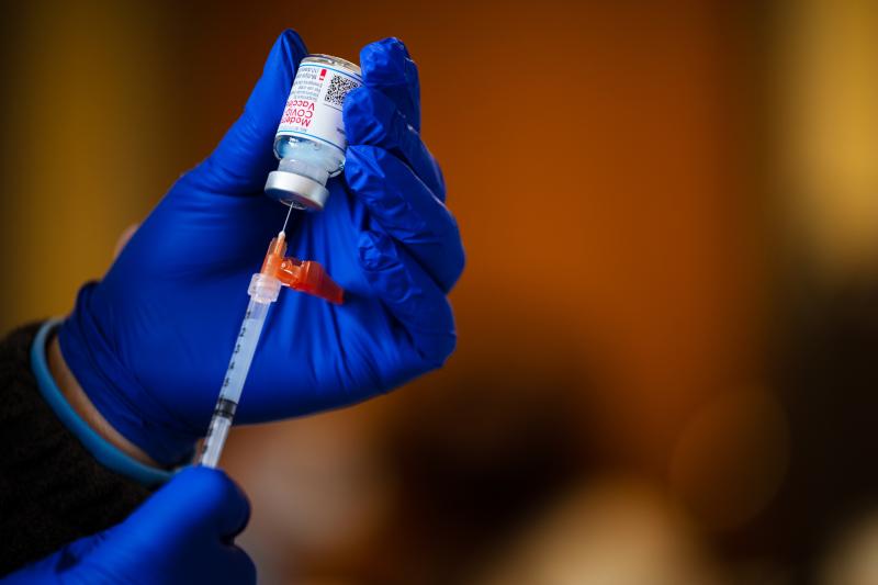 A technician fills a syringe from a vial of the Moderna COVID-19 vaccine earlier this year. A technician fills a syringe from a vial of the Moderna COVID-19 vaccine earlier this year.