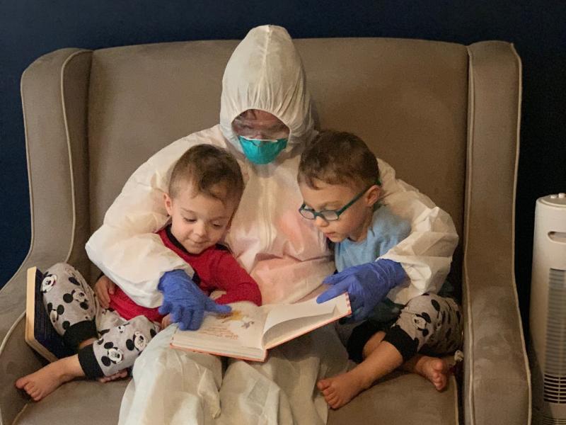 Dr. Lauren Jenkins reads to her twin sons, Pierce and Ashton, while wearing her "hazmat" suit. Because lung cancer has compromised her husband's immune system, Jenkins moved out of her home and visited in the suit as a precaution. Dr. Lauren Jenkins reads to her twin sons, Pierce and Ashton, while wearing her "hazmat" suit. Because lung cancer has compromised her husband's immune system, Jenkins moved out of her home and visited in the suit as a precaution.