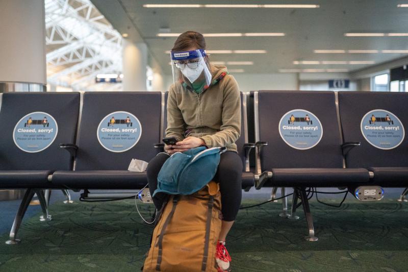 A traveler waits for a flight at Portland International Airport in Oregon last week. Public health experts say it's important that people who traveled or gathered with others are especially careful over the next two weeks. A traveler waits for a flight at Portland International Airport in Oregon last week. Public health experts say it's important that people who traveled or gathered with others are especially careful over the next two weeks.