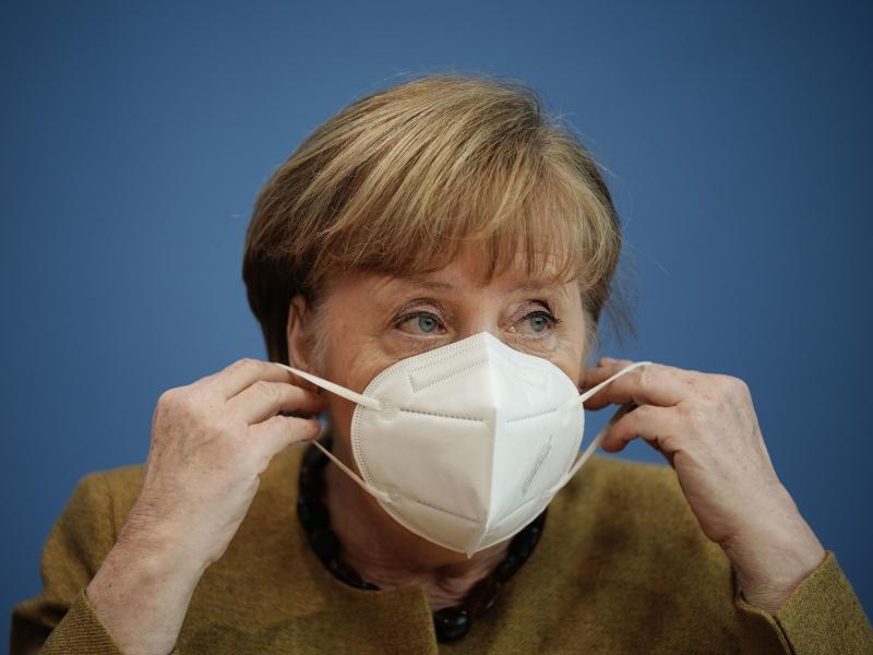 German Chancellor Angela Merkel puts on her face mask after a news conference in Berlin last week. Germany has introduced new requirements for medical-grade masks to be worn on public transit and in shops. German Chancellor Angela Merkel puts on her face mask after a news conference in Berlin last week. Germany has introduced new requirements for medical-grade masks to be worn on public transit and in shops.