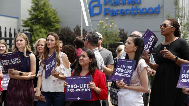 Anti-abortion-rights advocates gather outside a St. Louis Planned Parenthood clinic in June. Title X recipients have been given more time to comply with new regulations. Anti-abortion-rights advocates gather outside a St. Louis Planned Parenthood clinic in June. Title X recipients have been given more time to comply with new regulations.