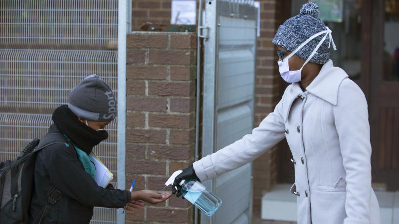 A pupil receives hand sanitizer upon returning to school in Johannesburg on July 6. Since easing its lockdown, coronavirus cases have spiked and the government is introducing some restrictions. A pupil receives hand sanitizer upon returning to school in Johannesburg on July 6. Since easing its lockdown, coronavirus cases have spiked and the government is introducing some restrictions.