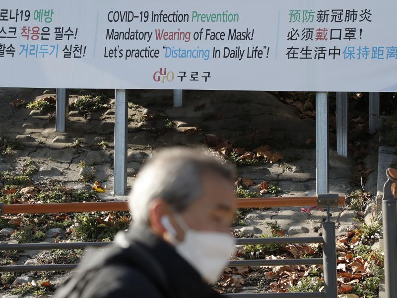 A man wearing a face mask walks past a banner showing precautions against the coronavirus in Seoul on Monday. A man wearing a face mask walks past a banner showing precautions against the coronavirus in Seoul on Monday.