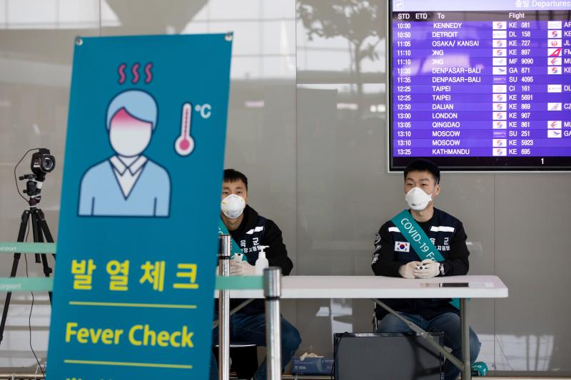 South Korean soldiers wearing protective masks sit at a temperature screening point at Incheon International Airport, South Korea, on March 9. South Korean soldiers wearing protective masks sit at a temperature screening point at Incheon International Airport, South Korea, on March 9.