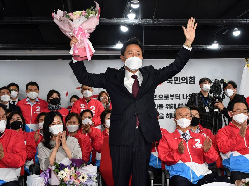 Oh Se-hoon (center), the mayoral candidate of the main opposition People Power Party, holds flowers as he celebrates with party members after exit polls showed he would win. Oh Se-hoon (center), the mayoral candidate of the main opposition People Power Party, holds flowers as he celebrates with party members after exit polls showed he would win.