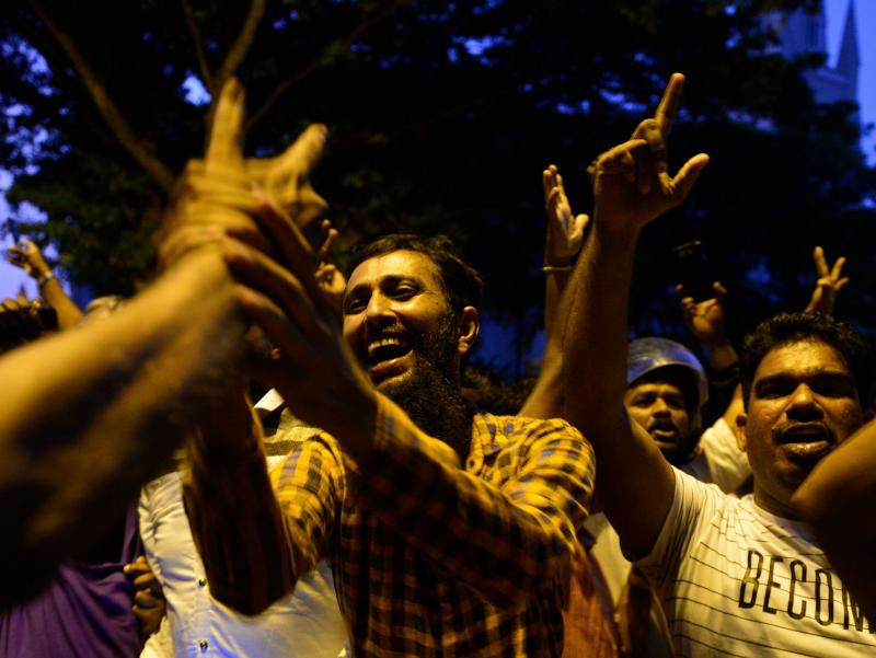 Supporters of ousted Sri Lankan Prime Minister Ranil Wickremesinghe shout in joy Tuesday outside the Supreme Court building in the capital, Colombo. Supporters of ousted Sri Lankan Prime Minister Ranil Wickremesinghe shout in joy Tuesday outside the Supreme Court building in the capital, Colombo.