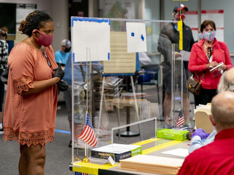 A voter stands by for her ballot as people wait more than four hours for early voting Friday in Fairfax, Va. A voter stands by for her ballot as people wait more than four hours for early voting Friday in Fairfax, Va.