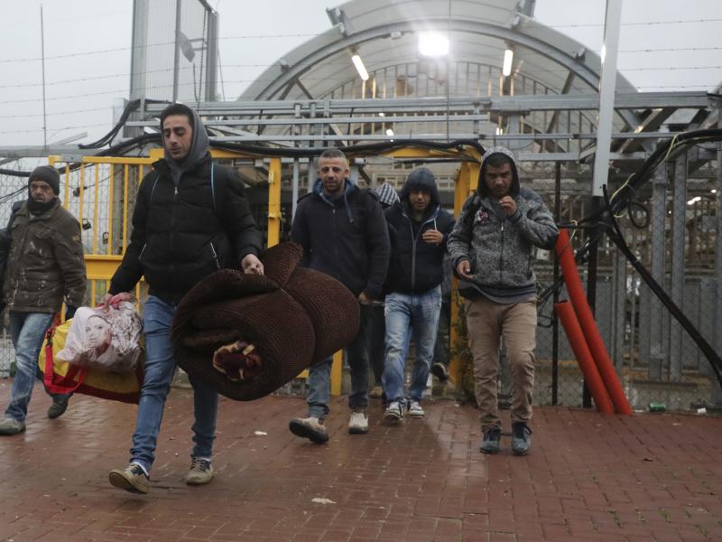 Palestinian laborers enter Israel on March 18 through a checkpoint between the West Bank city of Hebron and Beersheva. They carry blankets and mattresses, in preparation to stay in Israel amid the coronavirus pandemic. Palestinian laborers enter Israel on March 18 through a checkpoint between the West Bank city of Hebron and Beersheva. They carry blankets and mattresses, in preparation to stay in Israel amid the coronavirus pandemic.