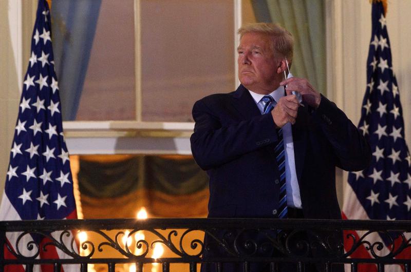 President Trump takes off his face mask Monday night as he arrives at the White House upon his return from Walter Reed National Military Medical Center. President Trump takes off his face mask Monday night as he arrives at the White House upon his return from Walter Reed National Military Medical Center.