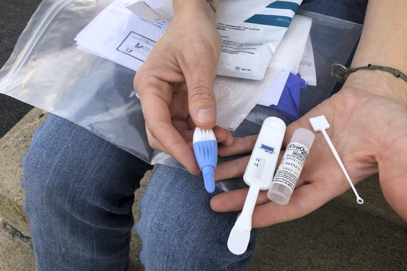 Brooke Parker, an organizer with the group Solutions Oriented Addiction Response, displays an HIV testing kit in Charleston, W.Va., in March. Outbreaks of HIV/AIDS are expected to rise as resources have been redirected to the fight against COVID-19 — de Brooke Parker, an organizer with the group Solutions Oriented Addiction Response, displays an HIV testing kit in Charleston, W.Va., in March. Outbreaks of HIV/AIDS are expected to rise as resources have been redirected to the fight against COVID-19 — de