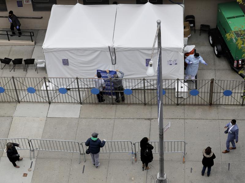 People stand in line as they wait to get tested for COVID-19 at a just-opened testing center in the Harlem section of New York on Monday. People stand in line as they wait to get tested for COVID-19 at a just-opened testing center in the Harlem section of New York on Monday.