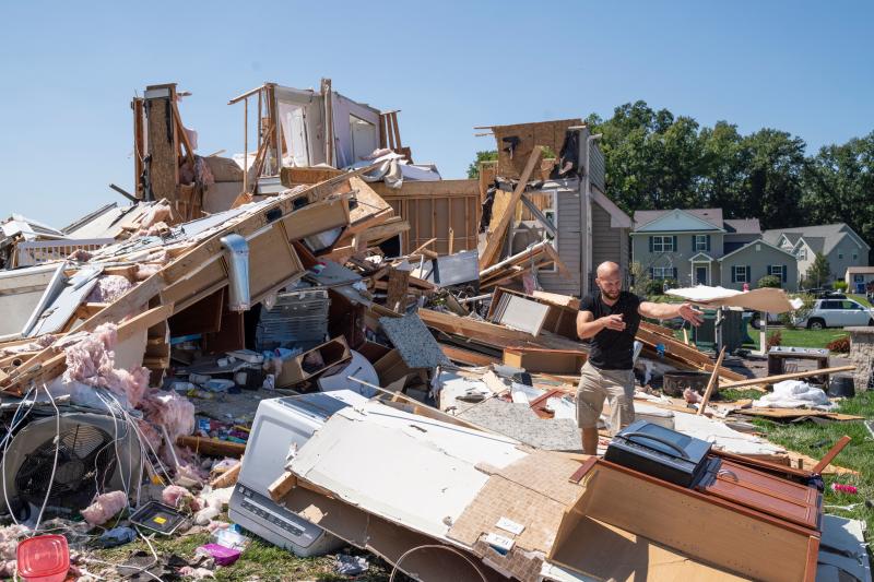 Sam Catrambone clears debris away from a friend's home that was damaged by a tornado in Mullica Hill, N.J., on Thursday after record-breaking rainfall brought by the remnants of Hurricane Ida that swept through the area. Sam Catrambone clears debris away from a friend's home that was damaged by a tornado in Mullica Hill, N.J., on Thursday after record-breaking rainfall brought by the remnants of Hurricane Ida that swept through the area.
