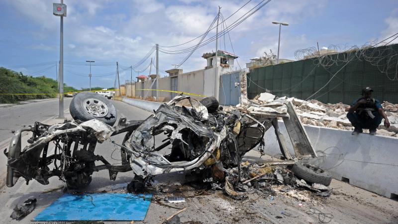 Somali soldiers stand guard next to wreckage from a car bomb outside the U.N.'s office in Mogadishu on Tuesday. At least 13 people were killed in twin bombings near U.N. and African Union buildings adjoining Mogadishu's airport, police said, in what the j Somali soldiers stand guard next to wreckage from a car bomb outside the U.N.'s office in Mogadishu on Tuesday. At least 13 people were killed in twin bombings near U.N. and African Union buildings adjoining Mogadishu's airport, police said, in what the j