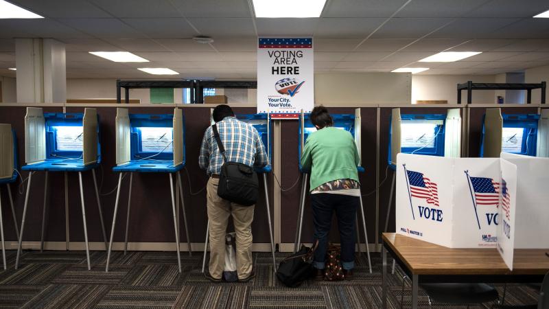 Joseph and Maria Caruso vote inside the Early Vote Center in downtown Minneapolis on Oct. 5, 2016. The Supreme Court on Thursday struck down a Minnesota law that prohibited voters from wearing politically themed items inside polling places. Joseph and Maria Caruso vote inside the Early Vote Center in downtown Minneapolis on Oct. 5, 2016. The Supreme Court on Thursday struck down a Minnesota law that prohibited voters from wearing politically themed items inside polling places.