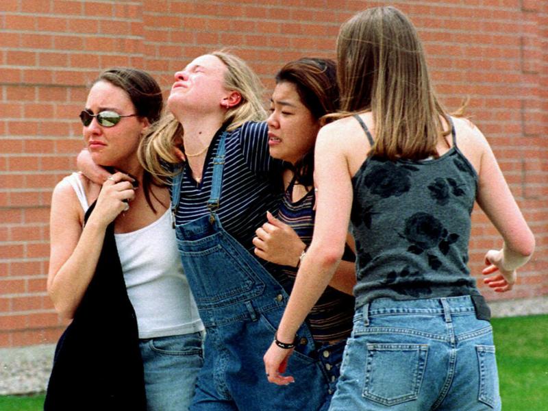 In this April 20, 1999, file photo, women head to a library near Columbine High School where students and faculty members were evacuated after two gunmen went on a shooting rampage in the school in the Denver suburb of Littleton, Colo. In this April 20, 1999, file photo, women head to a library near Columbine High School where students and faculty members were evacuated after two gunmen went on a shooting rampage in the school in the Denver suburb of Littleton, Colo.