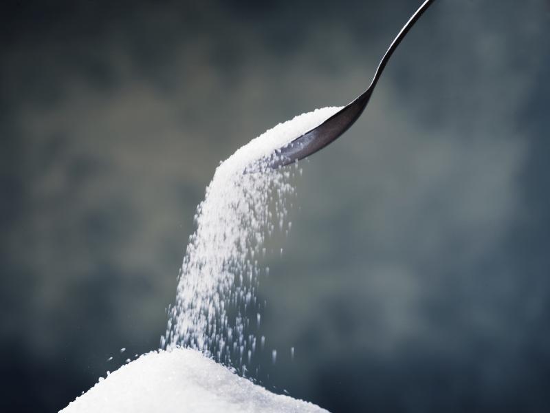 Sugar or artificial sweetener falling off of a spoon. Sugar or artificial sweetener falling off of a spoon.
