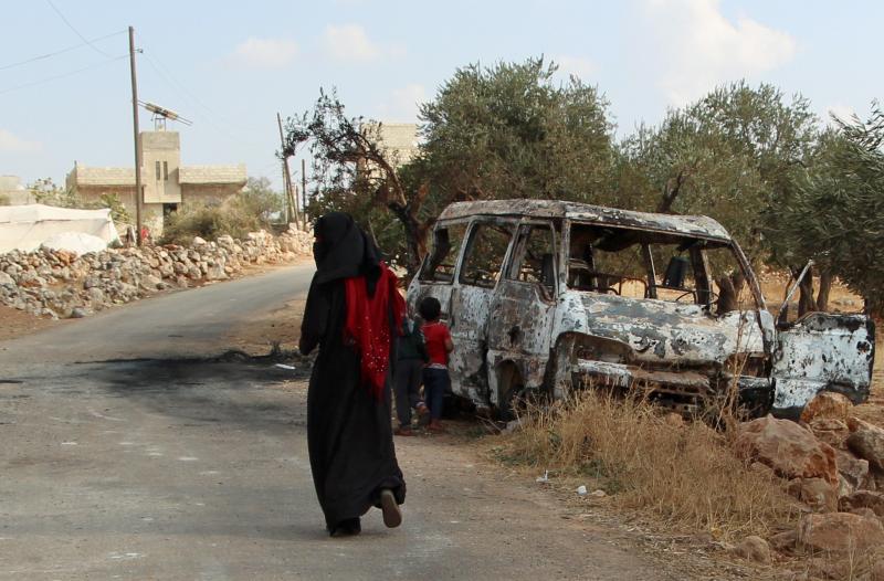 A woman walks past a wrecked van near the northwestern Syrian village of Barisha. Local residents and medical staff tell NPR that noncombatant civilians were killed and injured in the van the night of the U.S. raid on the compound of ISIS leader Abu Bakr A woman walks past a wrecked van near the northwestern Syrian village of Barisha. Local residents and medical staff tell NPR that noncombatant civilians were killed and injured in the van the night of the U.S. raid on the compound of ISIS leader Abu Bakr