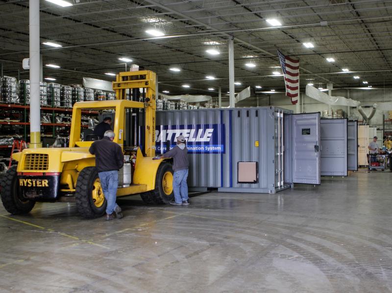 Workers inside a warehouse in Columbus, Ohio, prepare Battelle's decontamination units for deployment. Workers inside a warehouse in Columbus, Ohio, prepare Battelle's decontamination units for deployment.