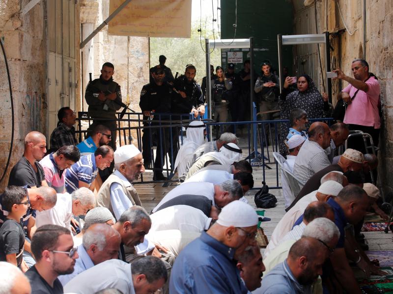 Palestinians pray near new metal detectors that were erected outside one of the main entrances to Al-Aqsa mosque in Jerusalem on Thursday. Increased security measures at the site have touched off protests. Palestinians pray near new metal detectors that were erected outside one of the main entrances to Al-Aqsa mosque in Jerusalem on Thursday. Increased security measures at the site have touched off protests.