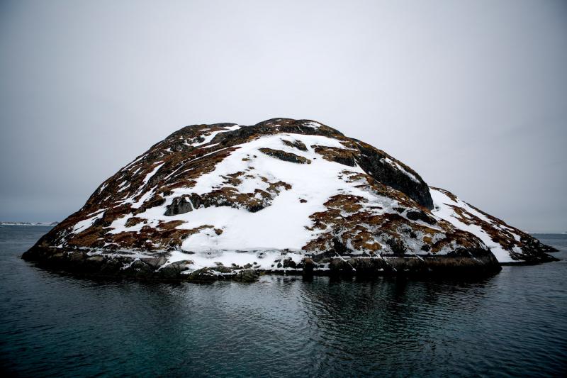 A small island sits in the middle of Kangeq's old harbor. A small island sits in the middle of Kangeq's old harbor.