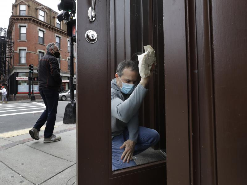 Manager Mike Bonavita wears a protective mask as he cleans windows at the Quattro Italian restaurant in Boston on May 12 during the coronavirus pandemic. This month, Massachusetts' governor declared wearing masks mandatory. Manager Mike Bonavita wears a protective mask as he cleans windows at the Quattro Italian restaurant in Boston on May 12 during the coronavirus pandemic. This month, Massachusetts' governor declared wearing masks mandatory.