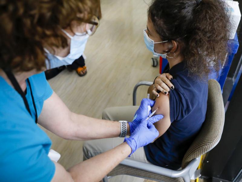 The CDC has softened its guidance for how to operate summer camps for kids this year. Children 12 and older can get the COVID-19 vaccine. Here, a health care worker administers a vaccine dose to a teenager in Miami. The CDC has softened its guidance for how to operate summer camps for kids this year. Children 12 and older can get the COVID-19 vaccine. Here, a health care worker administers a vaccine dose to a teenager in Miami.