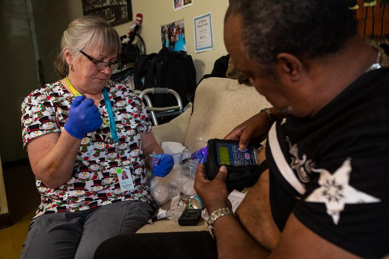 Arthur Jackson (right) gets blood tests during home visits in Boston from nurse Brenda Mastricola. He's also getting intravenous penicillin to treat a serious bone infection in his foot. The medication's pump is connected to an indwelling IV catheter. It' Arthur Jackson (right) gets blood tests during home visits in Boston from nurse Brenda Mastricola. He's also getting intravenous penicillin to treat a serious bone infection in his foot. The medication's pump is connected to an indwelling IV catheter. It'
