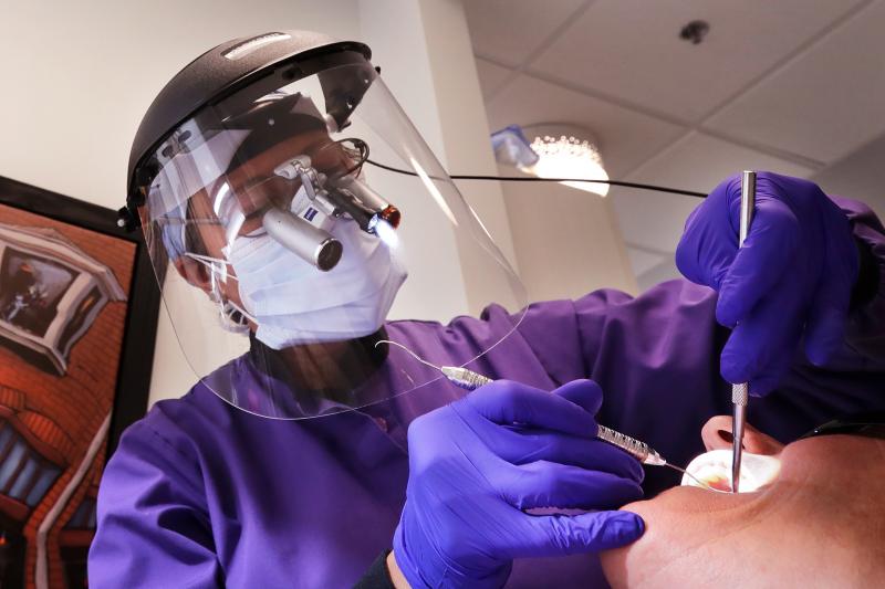 Dental offices have begun seeing patients return for routine procedures. Seattle dentist Kathleen Saturay has increased the layers of protective equipment she wears when treating patients. Dental offices have begun seeing patients return for routine procedures. Seattle dentist Kathleen Saturay has increased the layers of protective equipment she wears when treating patients.