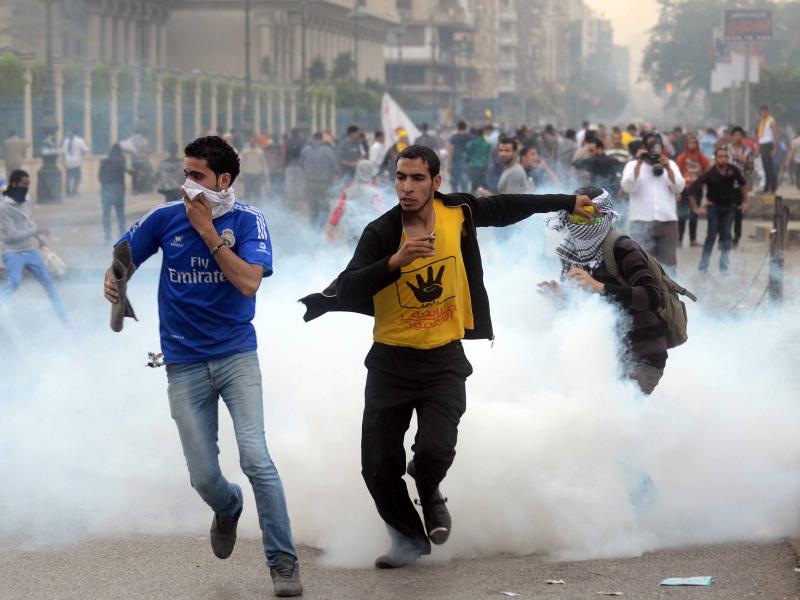 Supporters of the Muslim Brotherhood run from tear gas during clashes with riot police near Cairo's Rabaa al-Adawiya square on Nov. 22. Supporters of the Muslim Brotherhood run from tear gas during clashes with riot police near Cairo's Rabaa al-Adawiya square on Nov. 22.
