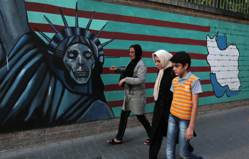 An Iranian family walks past anti-U.S. graffiti on the wall of the former U.S. embassy in Tehran on Tuesday. President Hassan Rouhani told Iranians that "all our objectives" have been met by a nuclear deal agreed upon Tuesday after talks with six world po An Iranian family walks past anti-U.S. graffiti on the wall of the former U.S. embassy in Tehran on Tuesday. President Hassan Rouhani told Iranians that "all our objectives" have been met by a nuclear deal agreed upon Tuesday after talks with six world po