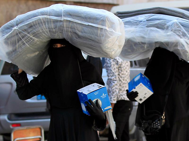 Yemeni women carry blankets and lanterns distributed by the United Nations High Commissioner for Refugees in Sanaa, Yemen. Yemeni women carry blankets and lanterns distributed by the United Nations High Commissioner for Refugees in Sanaa, Yemen.