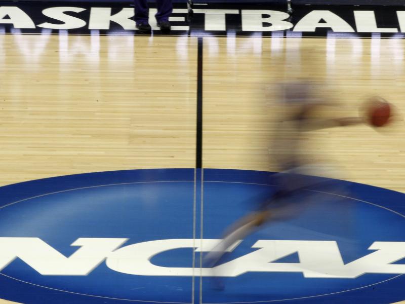 A player streaks across the NCAA logo at midcourt during basketball practice in this file photo from March 14, 2012. A player streaks across the NCAA logo at midcourt during basketball practice in this file photo from March 14, 2012.