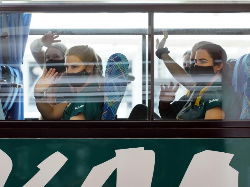 Australian softball players, the first foreign team to arrive for the Tokyo Olympic Games, wave from their bus after arriving at Narita International Airport on June 1. Australian softball players, the first foreign team to arrive for the Tokyo Olympic Games, wave from their bus after arriving at Narita International Airport on June 1.