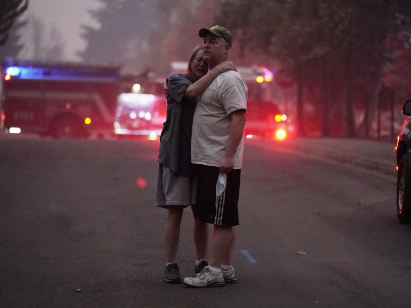 A couple embrace Thursday while touring an area devastated by the Almeda Fire in Phoenix, Ore. A couple embrace Thursday while touring an area devastated by the Almeda Fire in Phoenix, Ore.