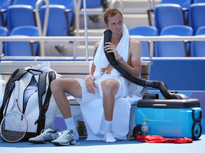 Daniil Medvedev cools down during the break with air from a mobile air conditioner and a towel with ice cubes at the Tokyo Olympics. Daniil Medvedev cools down during the break with air from a mobile air conditioner and a towel with ice cubes at the Tokyo Olympics.