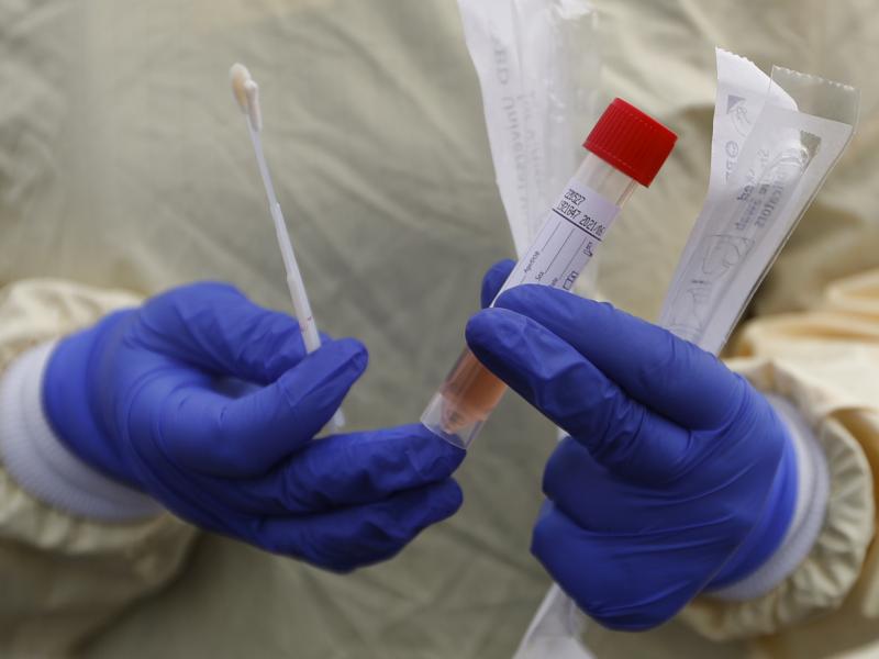 A nurse holds swabs and a test tube to test people for COVID-19 at a drive through station set up in the parking lot of the Beaumont Hospital in Royal Oak, Mich. A nurse holds swabs and a test tube to test people for COVID-19 at a drive through station set up in the parking lot of the Beaumont Hospital in Royal Oak, Mich.