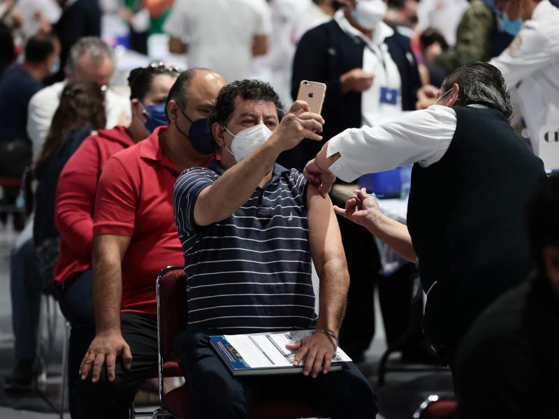 A man takes a selfie while getting the COVID-19 vaccine during a vaccination day in Mexico City. A man takes a selfie while getting the COVID-19 vaccine during a vaccination day in Mexico City.